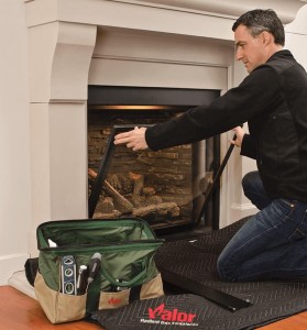 Technician removing glass from gas fireplace