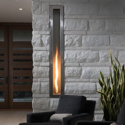 Helifire 360 columnar fireplace in a atone clad wall